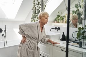 Senior caucasian woman in the bathroom having a strong backache
